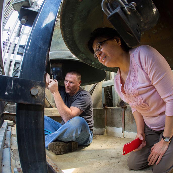 Carilloneur Tin-Shi Tam looks at the bell hookups on the mini carillon