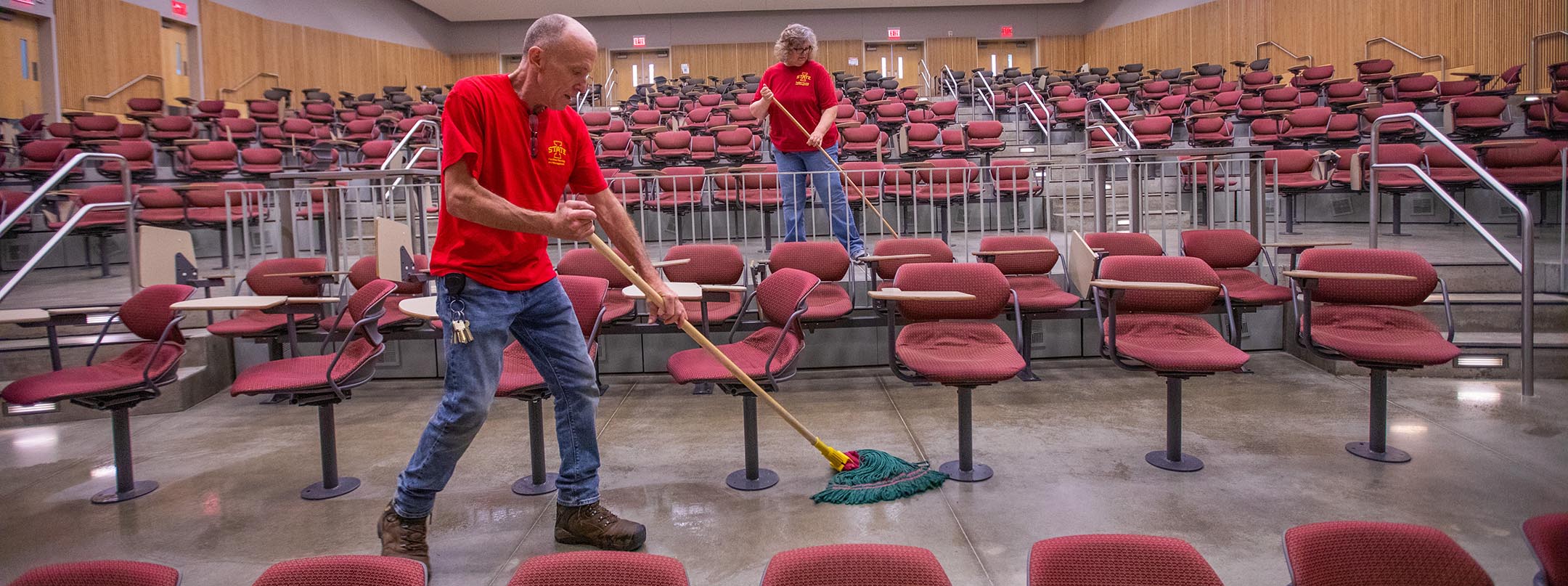 Custodians Eric Smay and Beth Paulsen clean the auditorium inside Troxel Hall each day following orientation programming. 