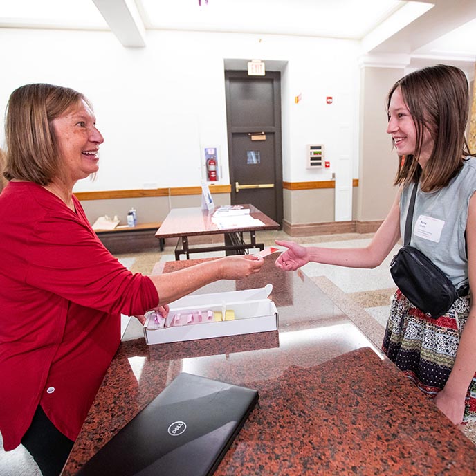 ISUCard manager Jody Pietz hands first-year student Raina Graalfs.