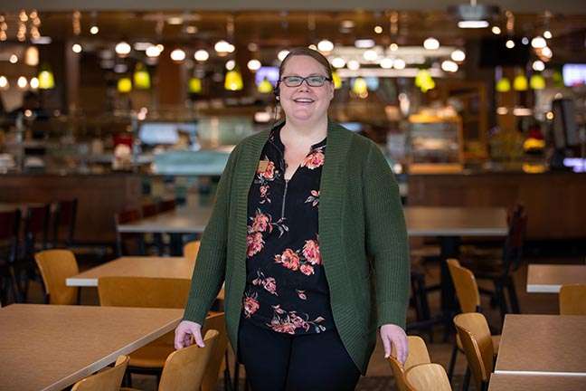 Dining services manager Kristin Duffy stands inside Seasons Marketplace where she is spending the month helping serve students and family members attending new student orientation.