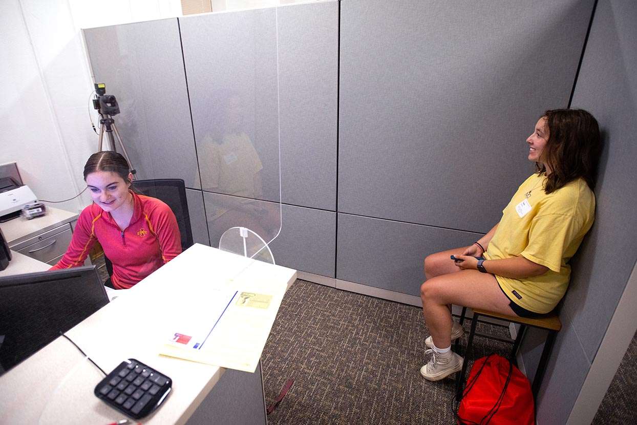 Student employee Jennifer Daharsh captures the photograph of first-year student Jenna Borwick in the ISUCard office.