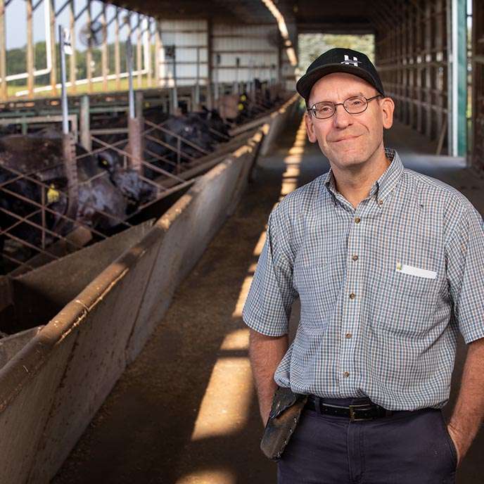 Garland Dahlke poses for an environmental portrait in the cattle barn.